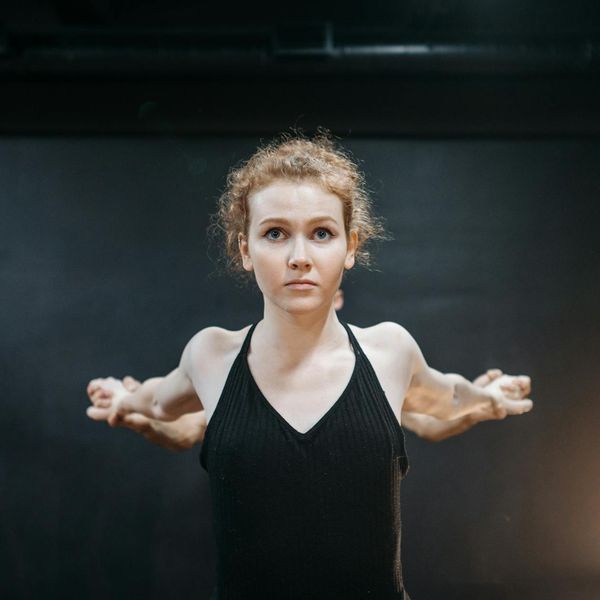 Woman in a balanced yoga pose looking calm and focused.
